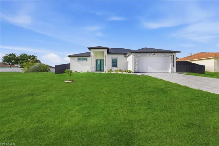 Prairie-style home with a garage, concrete driveway, and stucco siding