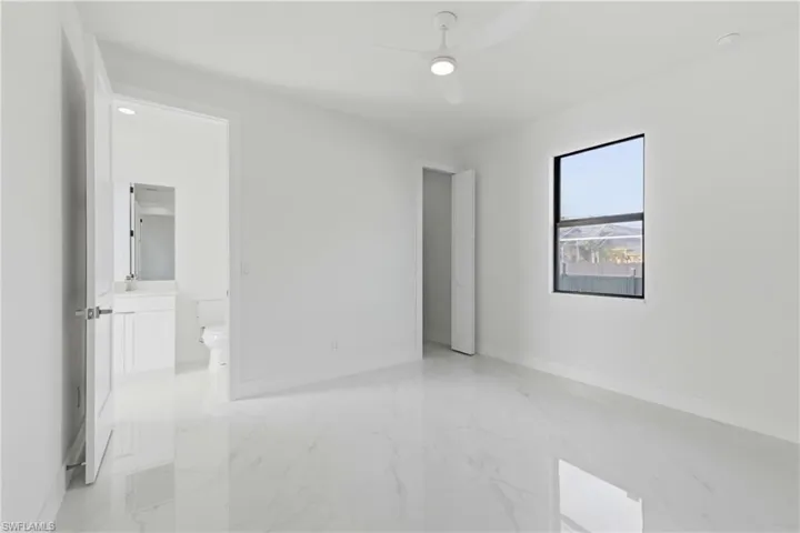 Unfurnished bedroom with light marble finish floors and ceiling fan