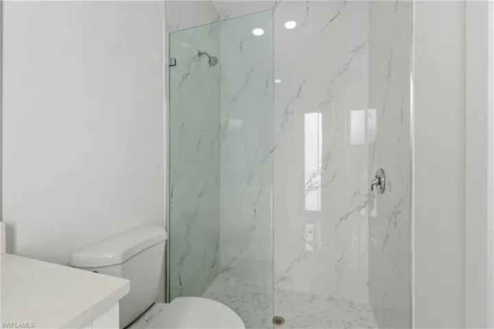Full bathroom with vanity and a marble finish shower