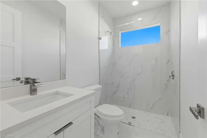 Full bathroom featuring vanity and a marble finish shower