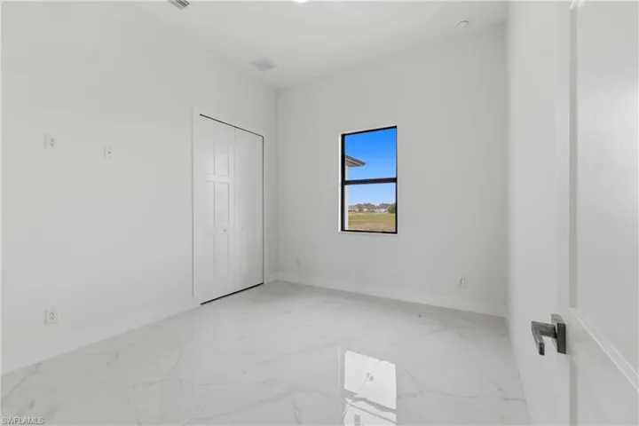 Unfurnished bedroom with light marble finish floors, a closet, and a ceiling fan