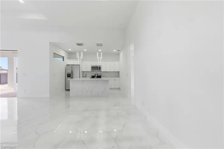Unfurnished living room with light marble finish flooring and recessed lighting