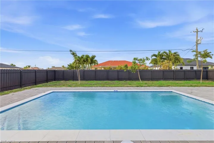 View of swimming pool with a fenced backyard and patio surround