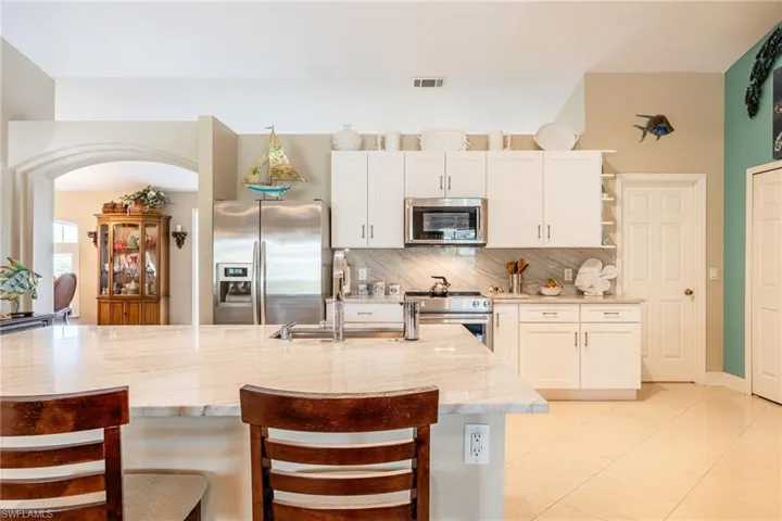 Kitchen with white shaker style cabinets, Quartzite countertops & stainless steel appliances