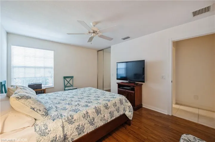 Bedroom with visible vents, ceiling fan, baseboards, and wood finished floors