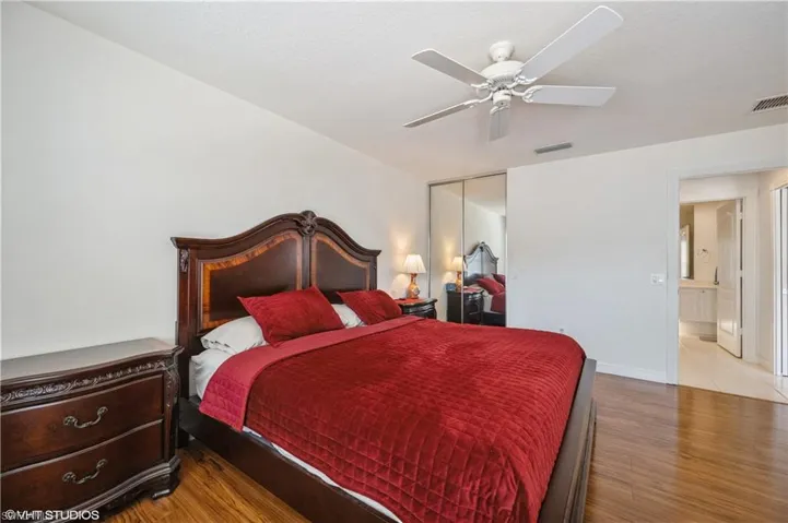 Bedroom with visible vents, a closet, a ceiling fan, and wood finished floors