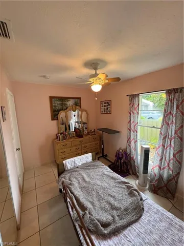 Bedroom featuring light tile patterned floors and ceiling fan