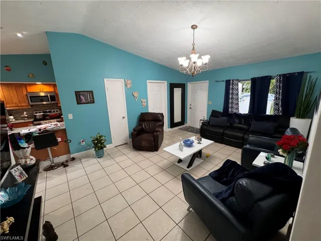 Tiled living room with lofted ceiling and a notable chandelier