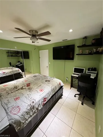 Bedroom featuring light tile patterned floors, a closet, and ceiling fan