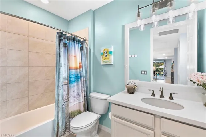 Full bath with vanity, shower / bath combo with shower curtain, and recessed lighting