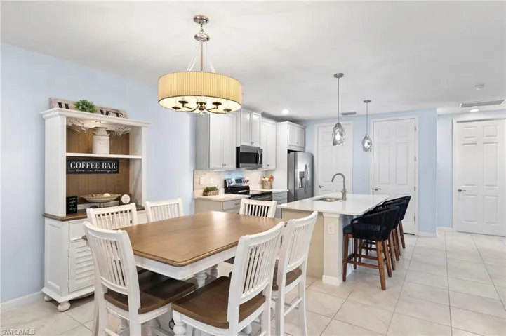 Dining area with light tile patterned floors and recessed lighting