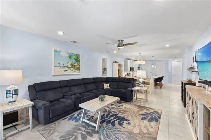 Living room featuring a ceiling fan, light tile patterned floors, and recessed lighting