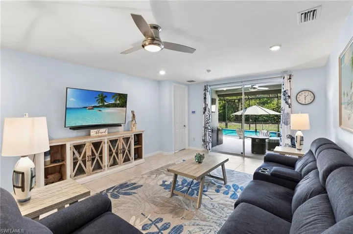 Living area with ceiling fan, a sunroom, tile patterned flooring, and recessed lighting