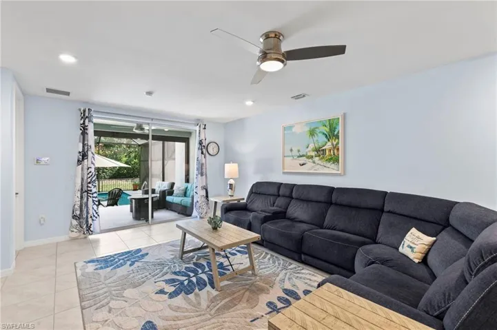 Living area with a ceiling fan, light tile patterned floors, and recessed lighting