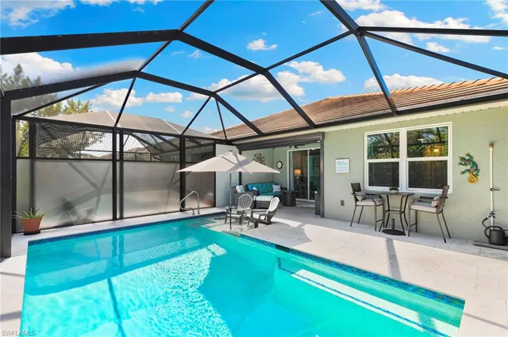 Swimming pool with a lanai, a sunroom, a patio area, and outdoor dining space