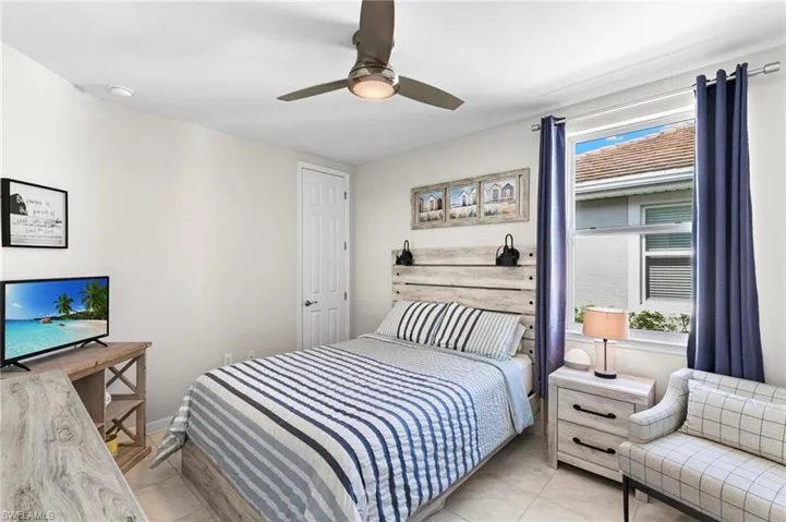 Bedroom with a ceiling fan and light tile patterned floors