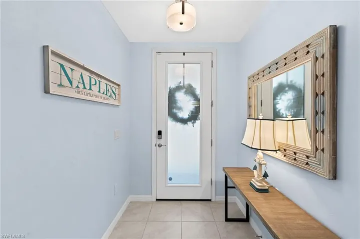 Foyer with baseboards and light tile patterned floors
