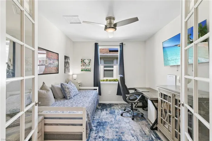 Bedroom with a desk, french doors, and a ceiling fan