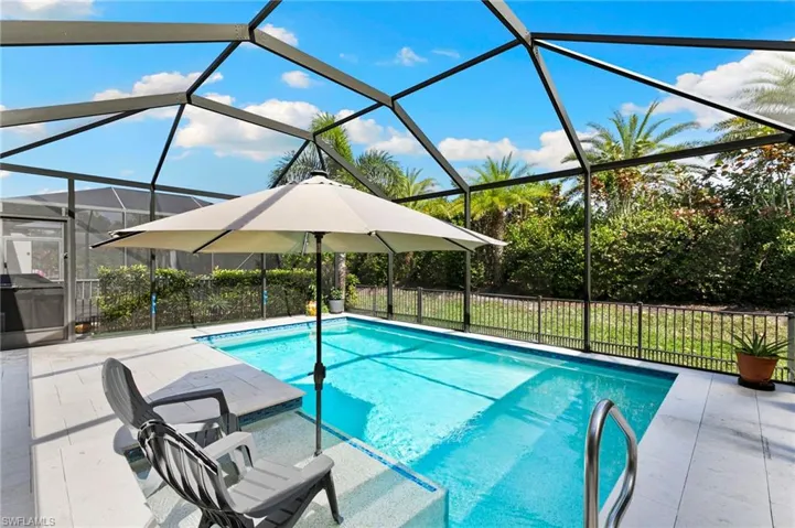 View of pool featuring a sunroom, a fenced backyard, a lanai, and patio surround