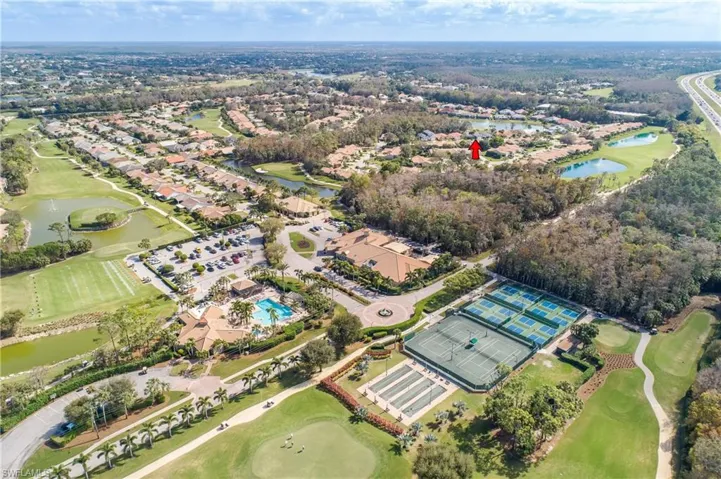 Aerial view of property's location featuring a golf club and nearby suburban area