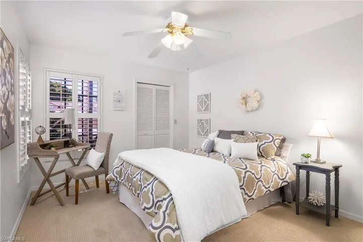 Bedroom featuring light carpet, a closet, and a ceiling fan
