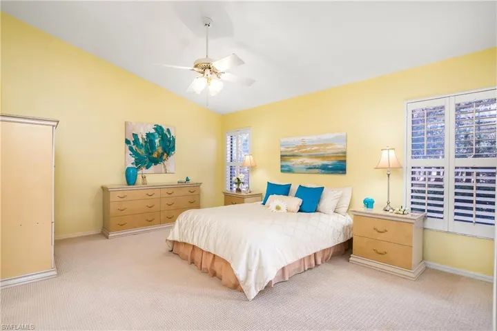 Bedroom featuring access to exterior, carpet floors, vaulted ceiling, and ceiling fan
