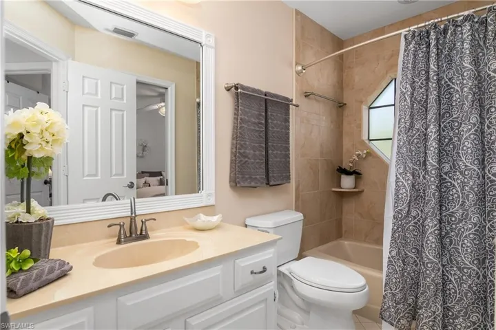 Ensuite bathroom featuring vanity and shower / tub combo with curtain