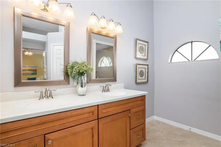 Full bath with a tile shower, vanity, and a walk in closet