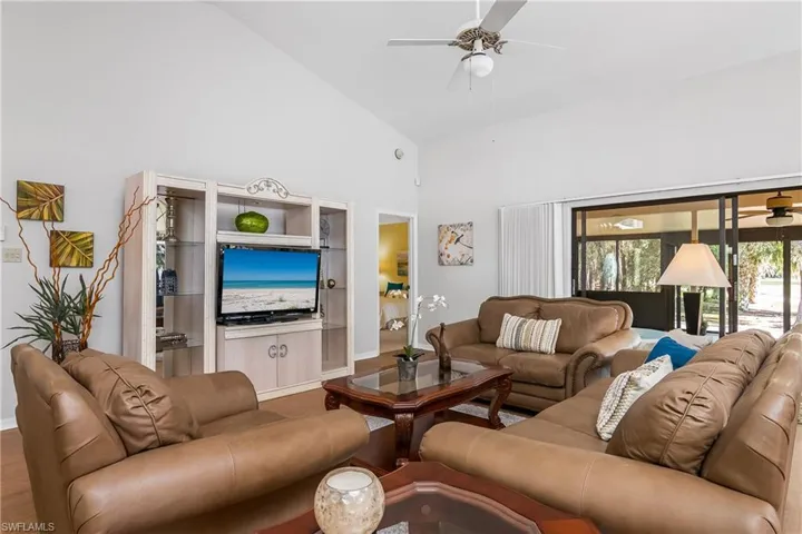 Living area featuring ceiling fan and lofted ceiling
