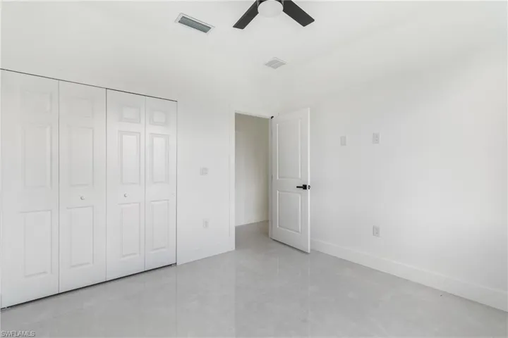 Unfurnished bedroom featuring a ceiling fan and a closet