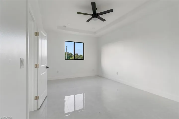 Empty room with a raised ceiling and ceiling fan