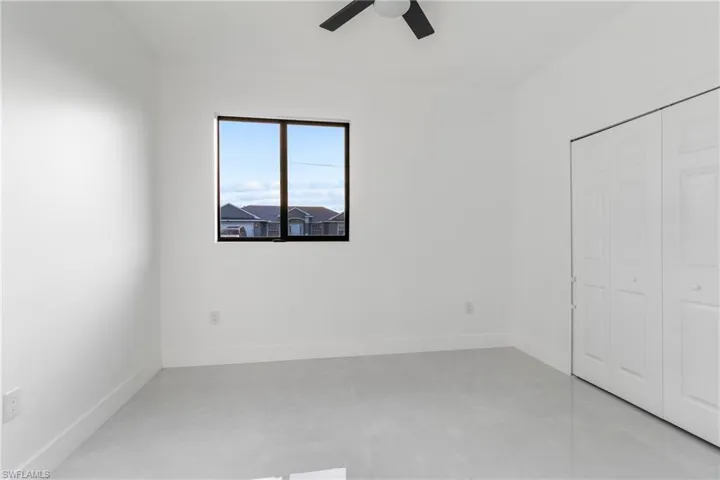 Unfurnished bedroom with a ceiling fan and a closet