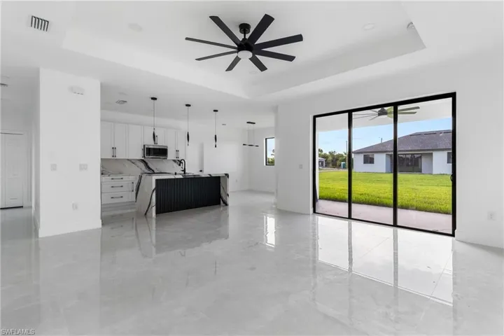 Kitchen featuring a tray ceiling, pendant lighting, and white cabinets