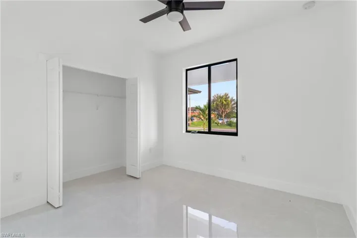 Unfurnished bedroom with a ceiling fan and a closet