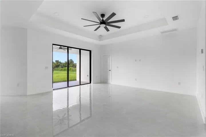 Spare room with a tray ceiling and a ceiling fan