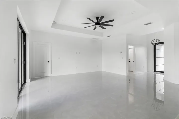 Spare room with a raised ceiling and a ceiling fan