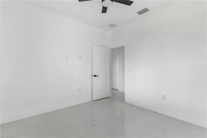 Empty room featuring baseboards and a ceiling fan