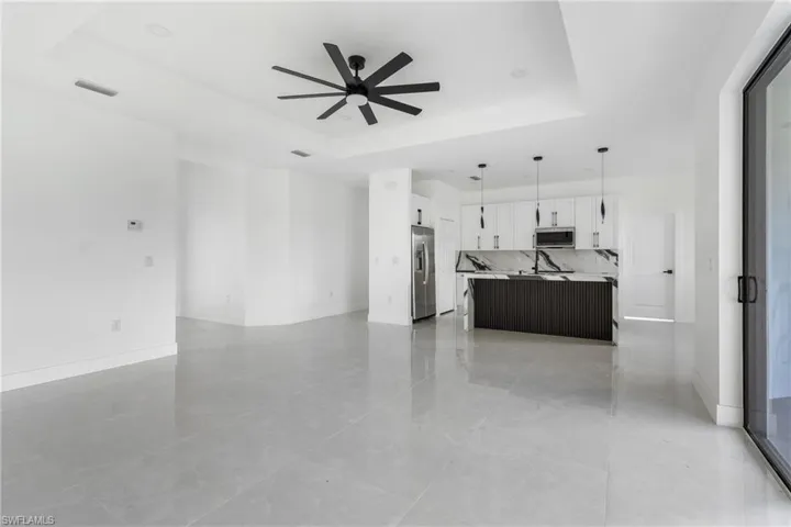 Living room featuring a tray ceiling and ceiling fan