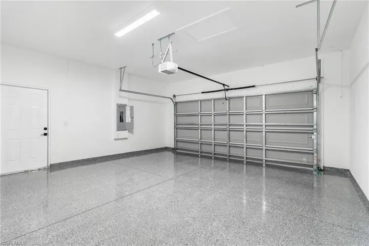 Garage with electric panel and a garage door opener