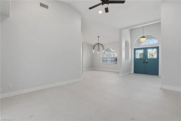 Entry foyer featuring double doors with transom window, vaulted ceiling, and recessed lighting