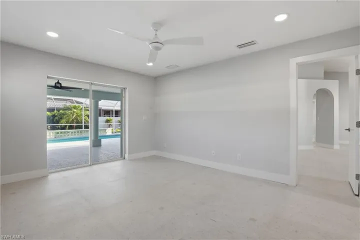 Expansive room featuring light gray walls and recessed lighting