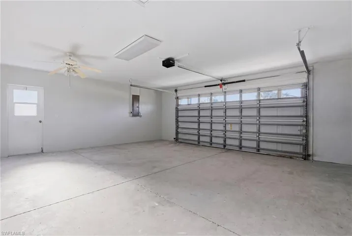 Spacious garage featuring a concrete floor, overhead lighting, and ceiling fan