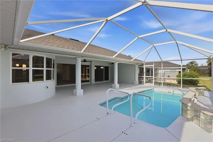 Screened patio featuring a swimming pool, integrated spa, and glass block accents