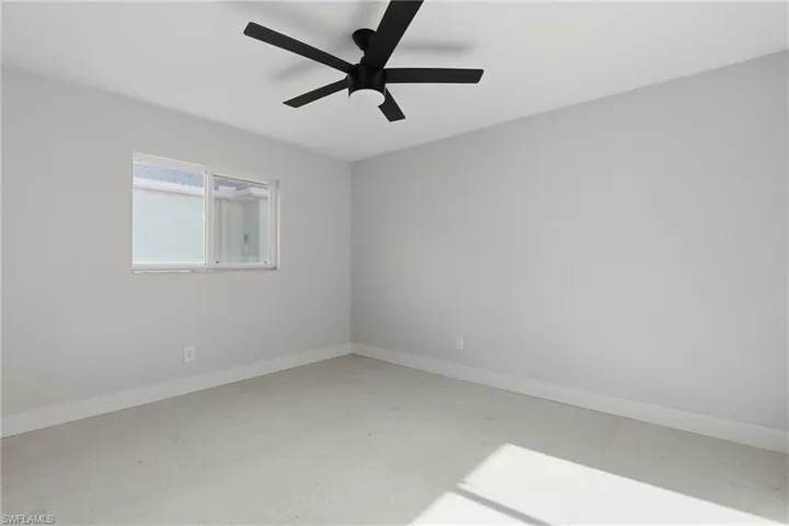 Neutral wall tones with white trim, a multi-pane window, and a contemporary ceiling fan