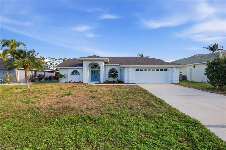 Light blue exterior with a dark shingle roof and a two-car garage