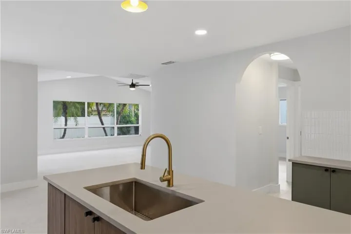 Kitchen island with a gold-finish gooseneck faucet and undermount stainless steel sink