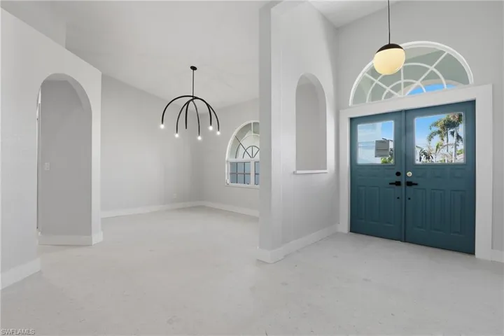 Entryway featuring double doors with glass panels and an arched transom window