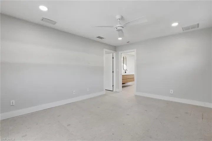 Spacious room featuring light-colored flooring, recessed lighting, and a ceiling fan