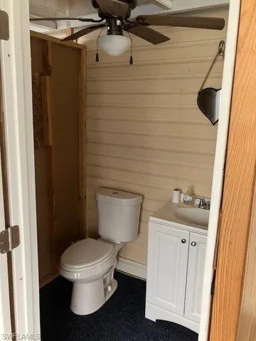 Bathroom featuring vanity, toilet, and ceiling fan