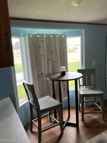Dining area featuring a textured ceiling and wood-type flooring